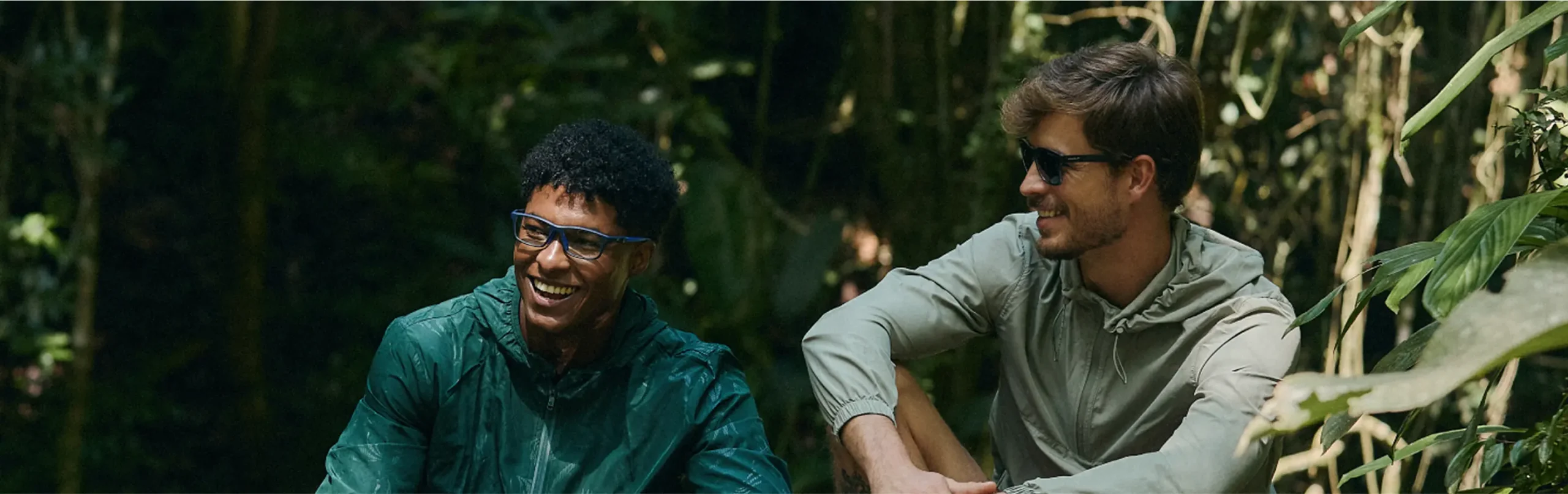 dois homens conversando e sorrindo em floresta oculos de grau e solar speedo