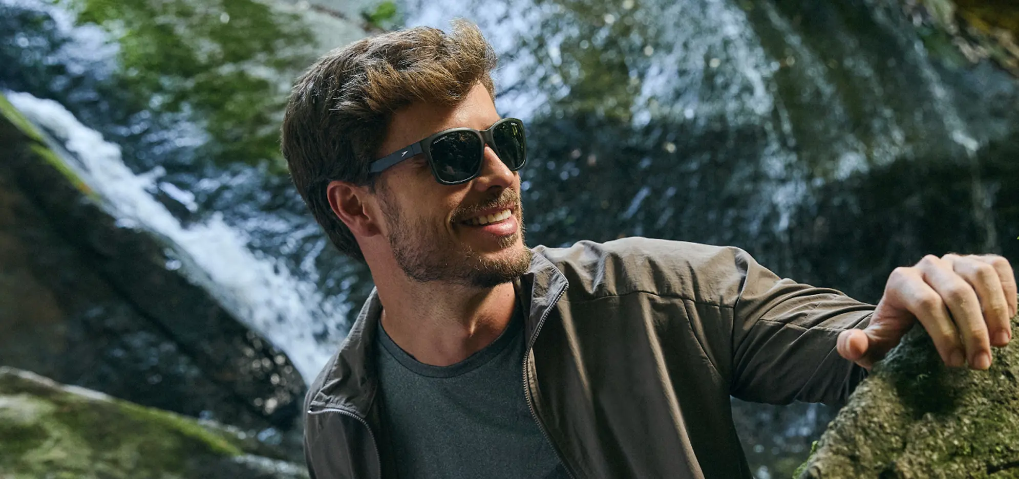 homem em cachoeira tirando foto com oculos solar speedo